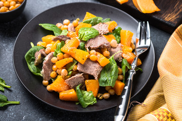 Warm salad with pumpkin, baked beef, spinach and chickpeas.