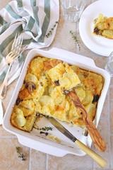 Vegetable gratin with potatoes, mushrooms and with cheese in ceramic bakeware