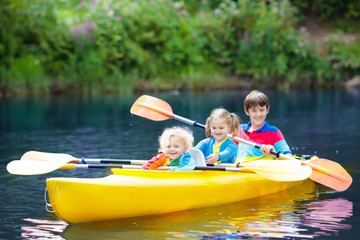 Child on kayak. Kids on canoe. Summer camping.