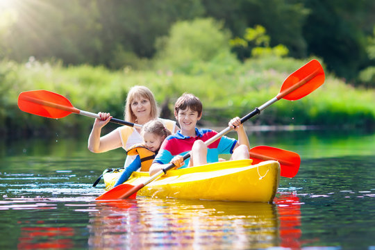 Child on kayak. Kids on canoe. Summer camping.
