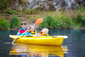 Child on kayak. Kids on canoe. Summer camping.