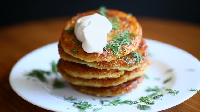 potato pancakes with dill in a plate on a wooden table