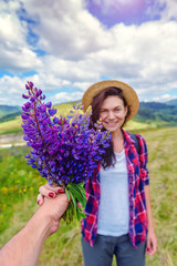 the girl takes a bouquet of lupine flower