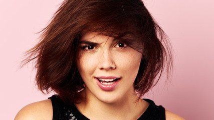 Obraz premium Pretty face girl looking forward over pink background.