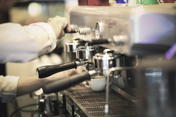 Hand of Barista making coffee with the coffee machine in the coffee shop or cafe, Foods and drink concept. Warm Tone.
