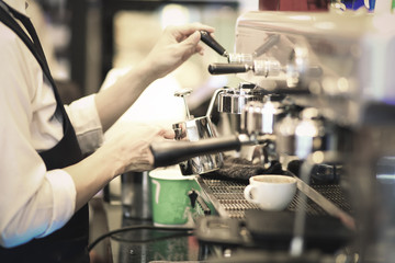 Hand of Barista making coffee with the coffee machine in the coffee shop or cafe, Foods and drink concept. Warm Tone.