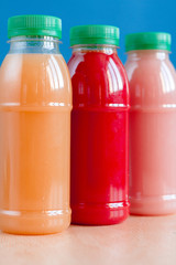 Three bottles of juice on a blue background
