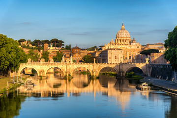 Fototapeta na wymiar Sunrise landscape view in early morning of St. Peters Basilica in the Vatican and the Ponte Sant'Angelo, Bridge of Angels, at the Castel Sant'Angelo and river Tiber in Rome, Italy