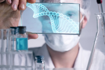 Fototapeta premium A physician, surgeon, examines a technological digital holographic plate represented the patient's body, the heart lungs, muscles, bones. Concept: Futuristic medicine, the human body, and the future.