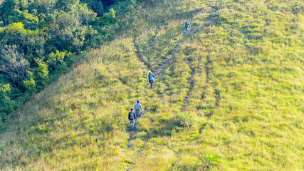 Fototapeta na wymiar group of people hiking in landscape green glass of high hill mountain in elevation view