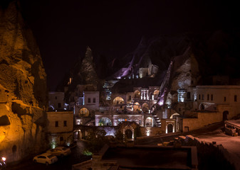 Night scene of the Uchisar Castle in Cappadocia. Illuminated view of famous Uchisar village, district of Nevsehir Province in the Central Anatolia Region of Turkey, Asia.