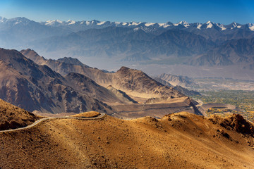 amazing beautiful landscape view of rural road on high mountain with snow mountain background in Leh - Ladakh northern of India