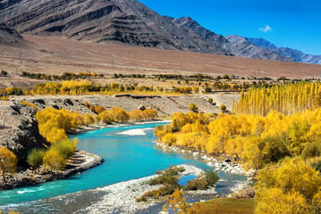 Blue River in autumn forest and mountain range. Nature composition.