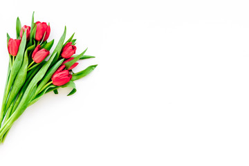 Bright red tulips for spring bouquet on white background top view copy space