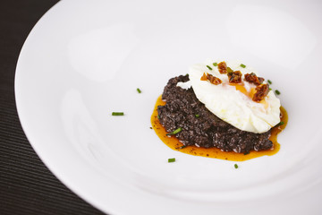 Modern dish with blood sausage and an egg.