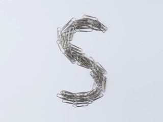 Letter S displayed with paperclips on white background
