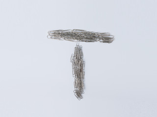 Letter T displayed with paperclips on white background