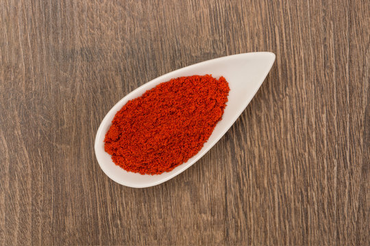 Red pepper powder over wood background