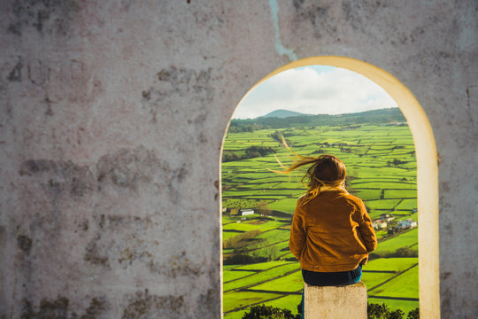 Woman in arch looking at field