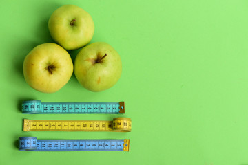 Sports and healthy lifestyle symbols. Apples near measuring tape rolls