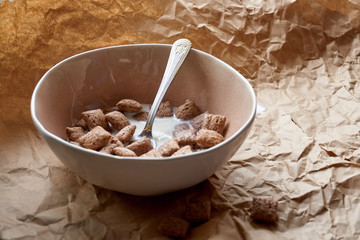 Dry breakfast is poured with milk into plates from a jug for milk