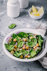Healthy green salad bowl with spinach, quinoa, chickpeas and red onions