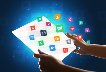 Hands touching a glass-like tablet with colorful icons
