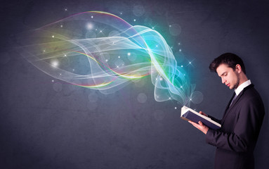 Young man holding book with waves