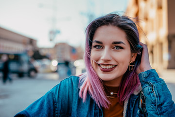 Close-up image of a smiling girl with purple hair.