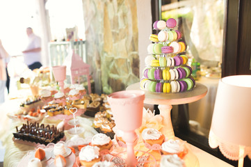 Delicious and tasty dessert table with cupcakes shots at reception closeup