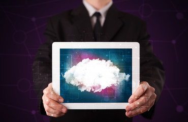 Businessman holding tablet with cloud graphic
