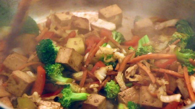 Tofu stir fry with vegetables cooking in pan	footage real time
