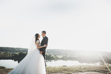 Wedding couple posing on sunset at wedding day. Bride and groom in love