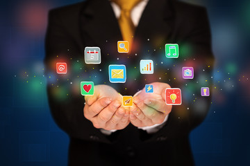 Businessman holding application icons