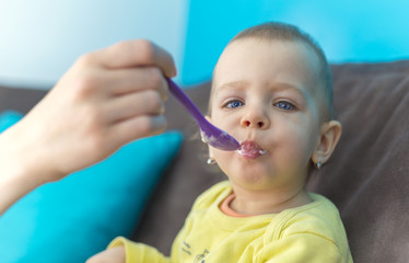 Feeding Her Baby Girl with a Spoon