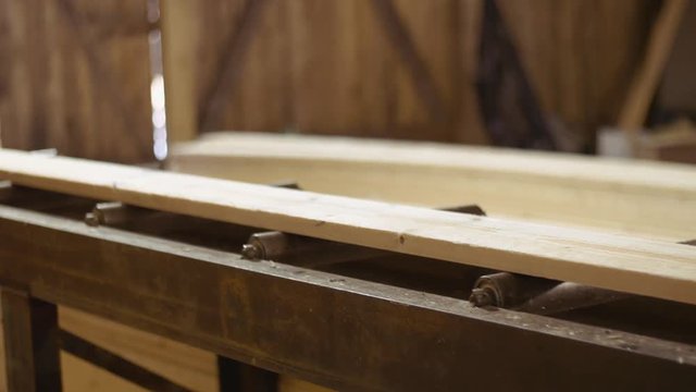 Wood board running out carpenter refiner machine at woodwork facility, lots of sawdust
