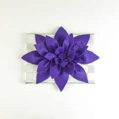 Homemade felt purple flower centerpiece with cup holders and napkin holder on white background - top view