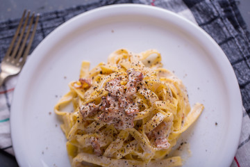close up of pasta carbonara, on a white plate with background