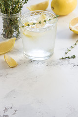 Detox water with lemon and thyme in glass, copy space