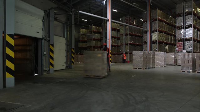 Special crane lowers containers with kvass bottles on warehouse of nonalcoholic plant, time lapse