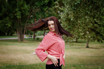 Happy young female develops hair and poses on camera