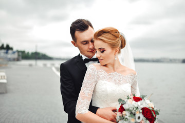 Posing for the camera. Young wedding couple. Romantic Married Couple. The bride and groom stand...