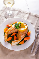 Salmon steak with lemon and a glass of wine on a napkin
