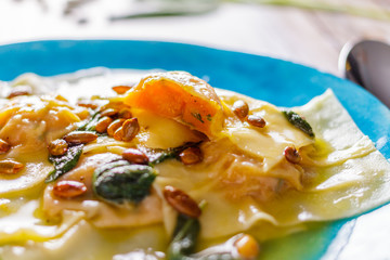 Homemade ravioli with pumpkin on a blue plate partial blur