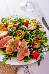 Salad with tuna on grill and arugula partial blurring vertical