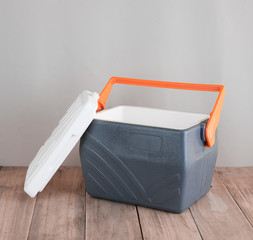 Handheld grey refrigerator on wood background © showcake