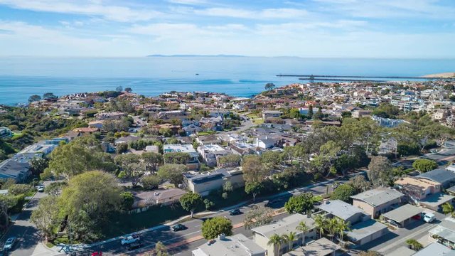 Aerial Time Lapse In Motion Over Coastal Orange County, California Neighborhood And PCH On Sunny Day With Luxury Homes Below.