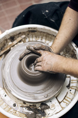 Artist makes clay pottery on a spin wheel