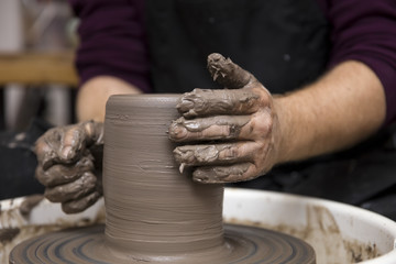 Artist makes clay pottery on a spin wheel