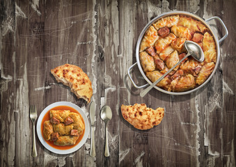 Stuffed Pickled Cabbage Rolls Cooked With Pork Dry Cured Ham And Smoked Ribs Served With Leavened Flatbread On Old Varnished Grunge Cracked Flaky Garden Table